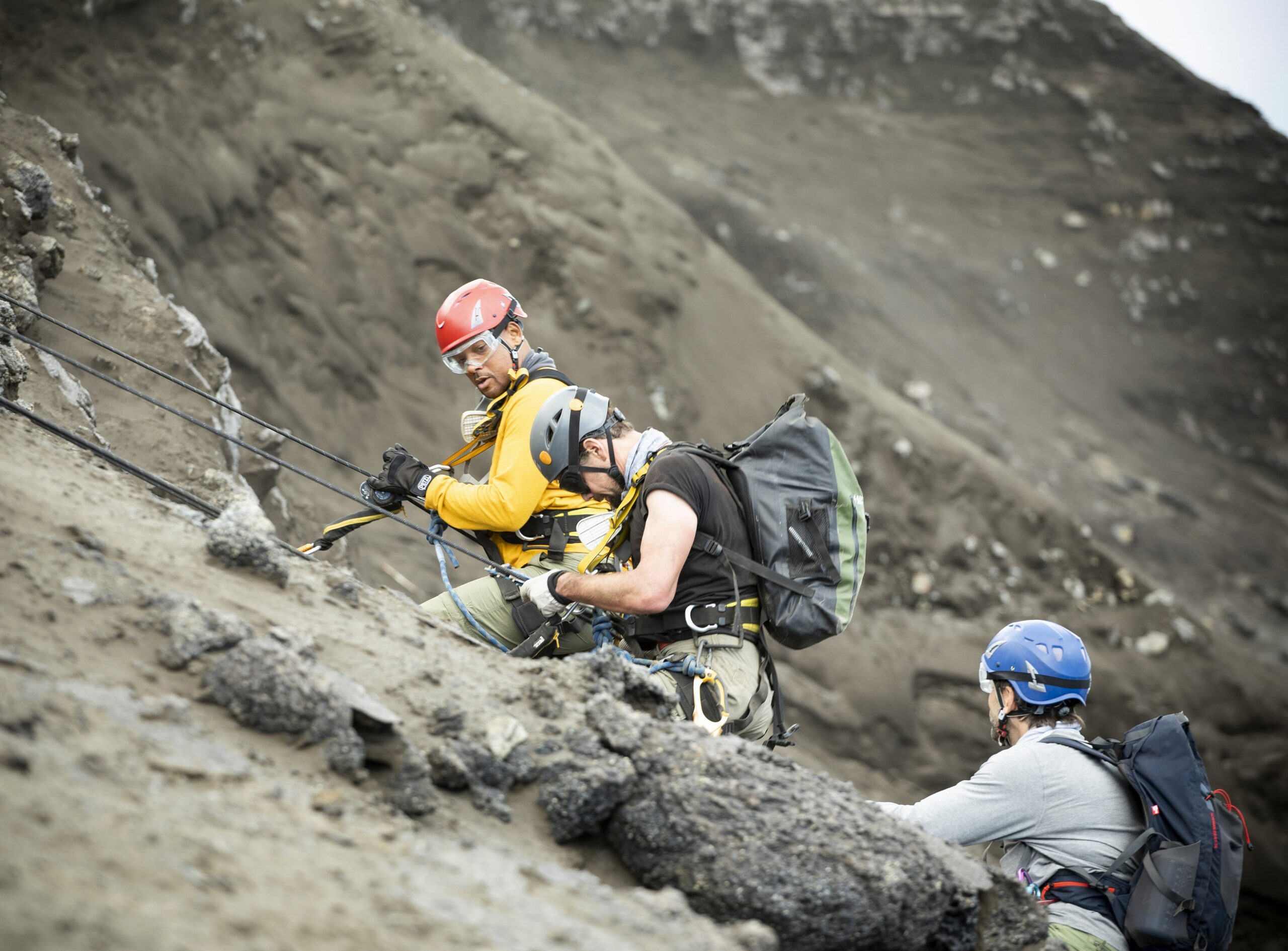 (L to R): Will Smith, Vulcanologist Jeff Johnson and Explorer Erik Weihenmayer descend into a volcano to install sensors. Photo: National Geographic for Disney+/Kyle Christy