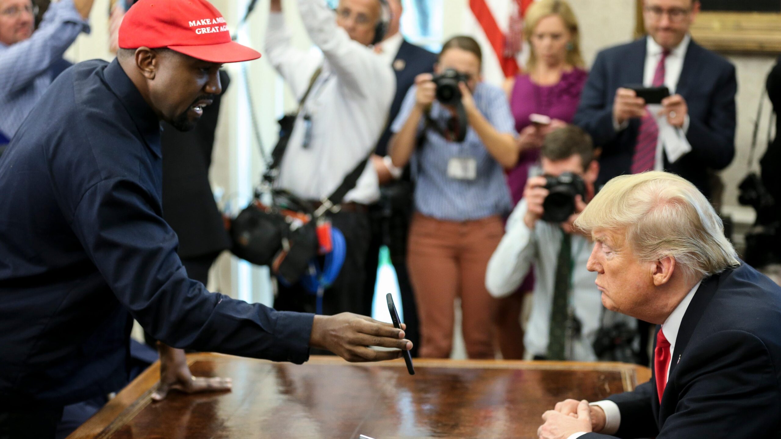 Kanye West , left, shows a picture of a plane to President Donald Trump during a meeting in the Oval office of the White House on October 11, 2018 in Washington, DC. Photo: AP Oliver Contreras/SIPA USA